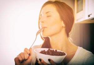 Picture of woman eating with a smile on her face