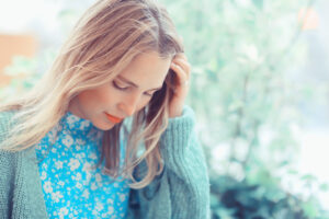 Picture of sad woman with her head on her hand