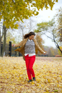 Picture of happy woman walking through the fall leaves