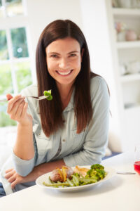 Picture of woman sititng at a table eating