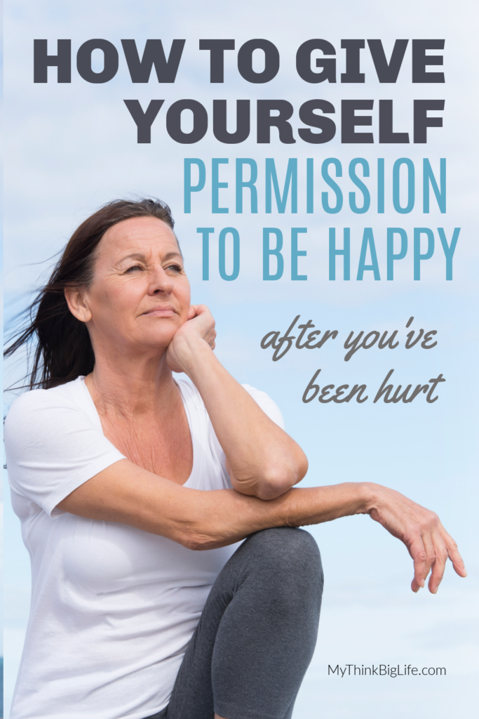 Picture of woman with arms on her knee with the words: How to give yourself permission to be happy after you've been hurt