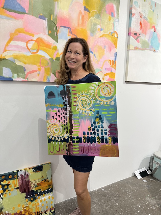 Picture of author sara holding a painting she painted in art class