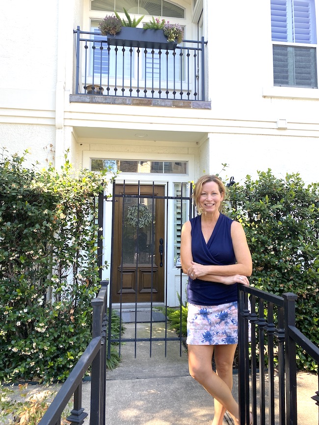 Picture of author Sara in front of a white house
