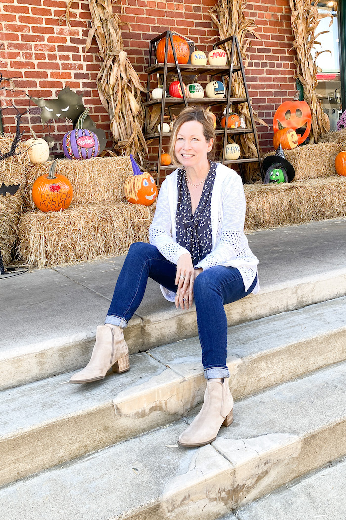 Picture of author Sara, sitting in front of pumpkin display