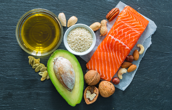 Picture of healthy fats such as avocado, nuts, olive oil, and salmon